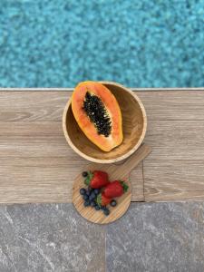 un melon et des baies sur une plaque en bois à côté d’une piscine dans l'établissement Villa Macher Piscina y Bar piscina, à Tías