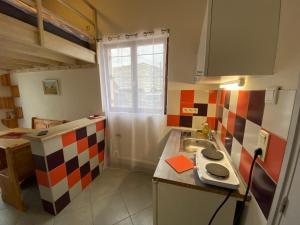 una pequeña cocina con fregadero y ventana en La Mezza - Wifi - stationnement - Terrasse, en Troyes