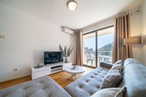 a living room with a couch and a tv at Luxury apartment near beach in Pržno