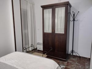 - une chambre avec une armoire en bois à côté d'un lit dans l'établissement Mi Rinconcito, à Baena