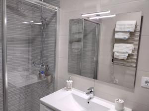 La salle de bains est pourvue d'un lavabo, d'une douche et d'un miroir. dans l'établissement Mi Rinconcito, à Baena
