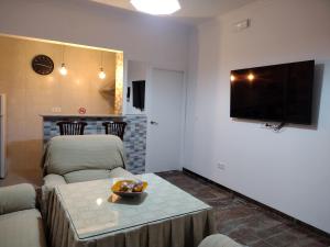 - un salon avec un canapé, une table et une télévision dans l'établissement Mi Rinconcito, à Baena