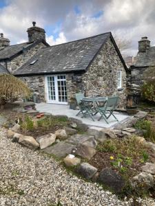 a stone cottage with a picnic table in front of it at Garth Engan Private Self Contained B&B with Garden Area in Llanbedr