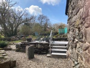 a stone wall with a staircase next to a stone building at Garth Engan Private Self Contained B&B with Garden Area in Llanbedr