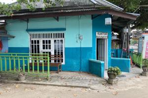 een blauw gebouw met een hek ervoor bij OYO Homes 91136 Desa Wisata Dalegan in Sukowati