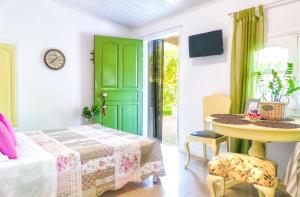 Habitación con puerta verde, mesa y mesa en PRETTY SPITI Holiday Home, en Laganas