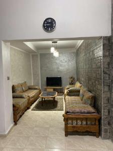 uma sala de estar com sofás e um relógio na parede em Bizerte maison en plein cœur de la médina em Bizerte