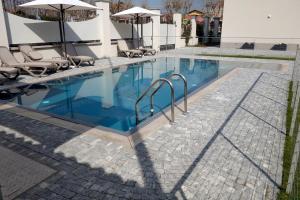 a pool with chairs and umbrellas next to a building at VILLA BERNASCONI in Narzole