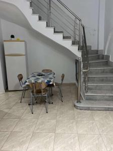 comedor con mesa, sillas y escaleras en Bizerte maison en plein cœur de la médina en Bizerte