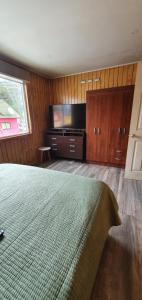 a bedroom with a bed and a flat screen tv at El Capitán in Puerto Montt