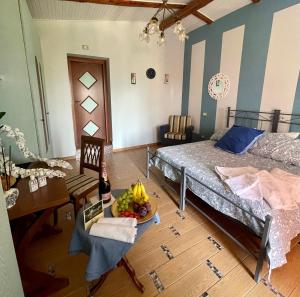 カーヴァ・デ・ティッレーニにあるVilla Simitodeのベッド1台、テーブル(フルーツボウル付)が備わる客室です。