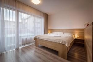 a bedroom with a bed and a large window at Horský apartmán Hrebienok A203 in Smokovce