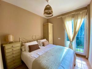 アラセナにあるCasa Rural La Senda de Arocheのベッドルーム1室(ドレッサー付きのベッド1台、窓付)