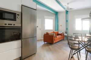 a kitchen and living room with a couch and a table at Apartamento Deluxe El Avión in Alcalá de Henares