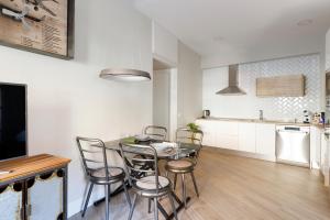 a kitchen and dining room with a table and chairs at Apartamento Deluxe El Avión in Alcalá de Henares