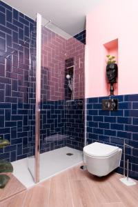 a bathroom with a toilet and a shower with blue tiles at Apartamento Deluxe El Avión in Alcalá de Henares