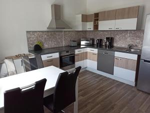 a kitchen with a white table and a white counter top at Ferienwohnung am Hopfenstodl in Illschwang