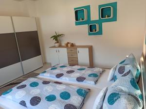 a bedroom with two beds and a plant on the wall at Ferienwohnung am Hopfenstodl in Illschwang