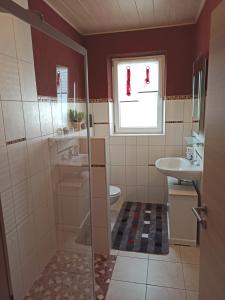 a bathroom with a sink and a toilet and a window at Ferienwohnung am Hopfenstodl in Illschwang