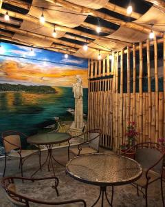 南聖胡安的住宿－Tapihouse San Juan Del Sur，一间设有桌椅的房间和一幅雕像画