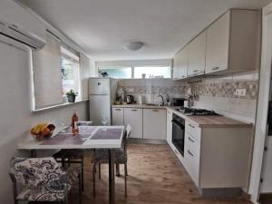 a kitchen with white appliances and a table with chairs at Apartman Ane - Bribir in Bribir