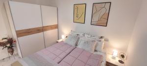 Dormitorio pequeño con cama con sábanas y almohadas rosas en ISTRIANA, en Koper