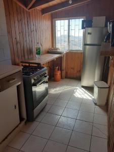 a kitchen with a stove and a refrigerator at Curanipe: primera linea de playa. in Curanipe