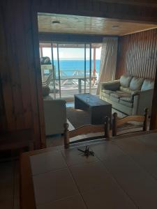 a living room with a view of the ocean at Curanipe: primera linea de playa. in Curanipe