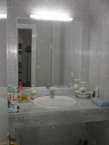 ein Badezimmer mit einem Waschbecken und einem großen Spiegel in der Unterkunft PRECIOSO APARTAMENTO AL LADO DE BONITA CALA in Ciutadella