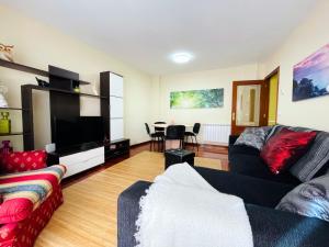 a living room with a couch and a television at Piso Céntrico Nati Con Parking Incluído in O Grove