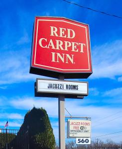 un cartello rosso di una locanda per falegnami su un palo di Red Carpet Inn West Springfield a West Springfield