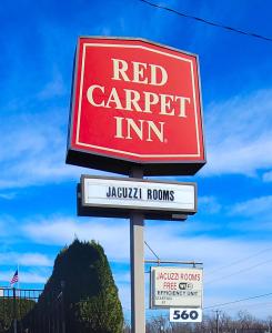 un cartel de carpintero rojo en un poste en Red Carpet Inn West Springfield en West Springfield