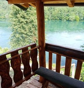 a view of a river from a porch with a bench at Popović na Drini in Bajina Bašta