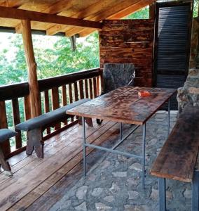 a wooden table and chairs on a wooden deck at Popović na Drini in Bajina Bašta