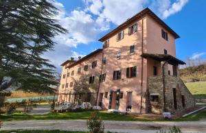 an old stone building in a field with trees at Il Moro Country House in Sant'Orfeto