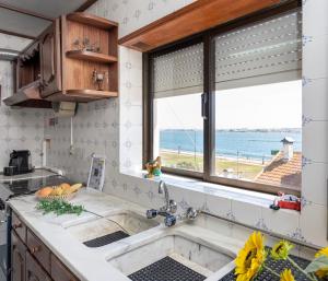 a kitchen with a sink and a window at Casa Golfinho (2ºandar) - Costa Nova in Gafanha da Encarnação