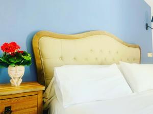 a bed with a vase of flowers on a night stand at Alda Hospedería De Los Reyes in Toledo