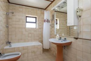 a bathroom with a sink and a tub and a toilet at Casa Golfinho (2ºandar) - Costa Nova in Gafanha da Encarnação +5 photos
