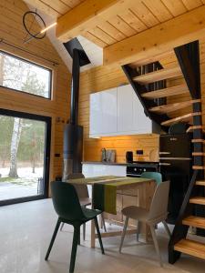 a kitchen and dining room with a table and chairs at Na Wrzosowej, domy z bala PREMIUM, blisko Suntago in Franciszków