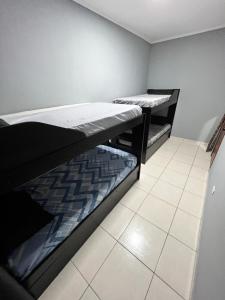 Cette chambre dispose de deux lits superposés et de carrelage. dans l'établissement Apto Luxo Praia Grande 50m da Praia WI-FI Familiar, à Praia Grande