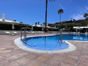 a swimming pool in a resort with palm trees at Ahtha Green Bungalow Maspalomas in San Bartolomé de Tirajana