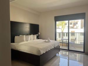 a bedroom with a large bed and a balcony at Mizirawi Historic Hotel in Ramallah