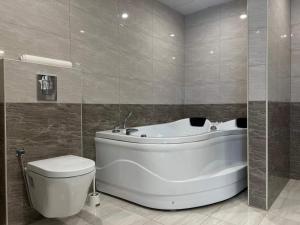 een badkamer met een wit bad en een toilet bij Mizirawi Historic Hotel in Ramallah