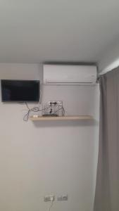 a shelf in a room with a refrigerator with a tv at apartament bermudas in Benidorm