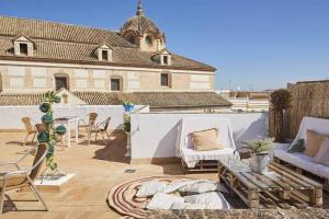 a patio with couches and a table and a building at El Patio del Limonero in Écija