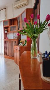 a vase of pink flowers sitting on a counter in a kitchen at Casa Bianca B&B in Ostuni