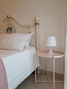a bed and a table with a lamp on it at Casa Bianca B&B in Ostuni