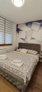 a bedroom with a large bed with towels on it at MOON LUX Apartman Beograd in Belgrade