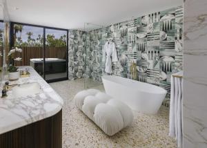 a bath room with a white tub and a white toilet at L'Horizon Resort & Spa in Palm Springs