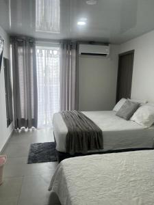 1 dormitorio con 2 camas y ventana grande en Summer Breeze en San Andrés